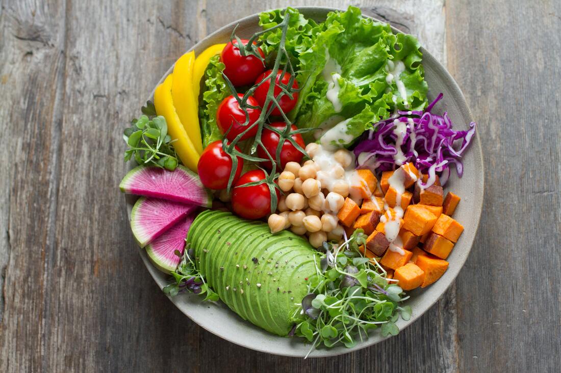 a white plate full of bright coloured fresh vegetables