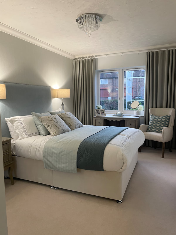 a double bedroom fully made up in cream and teal at churchill retirement living