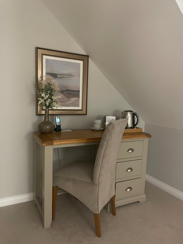 dressing table, tea and coffee making, chair and flower vase at beeches lodge,