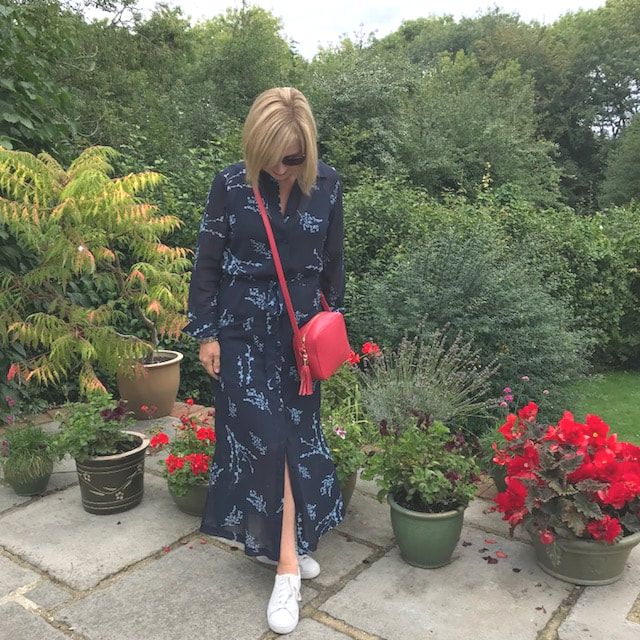 woman in navy shirt dress with red handbag