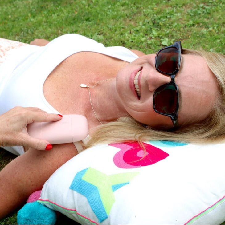 Michelle is laying on the grass holding fussy natural deodorant | blush pink case | fussy deodorant