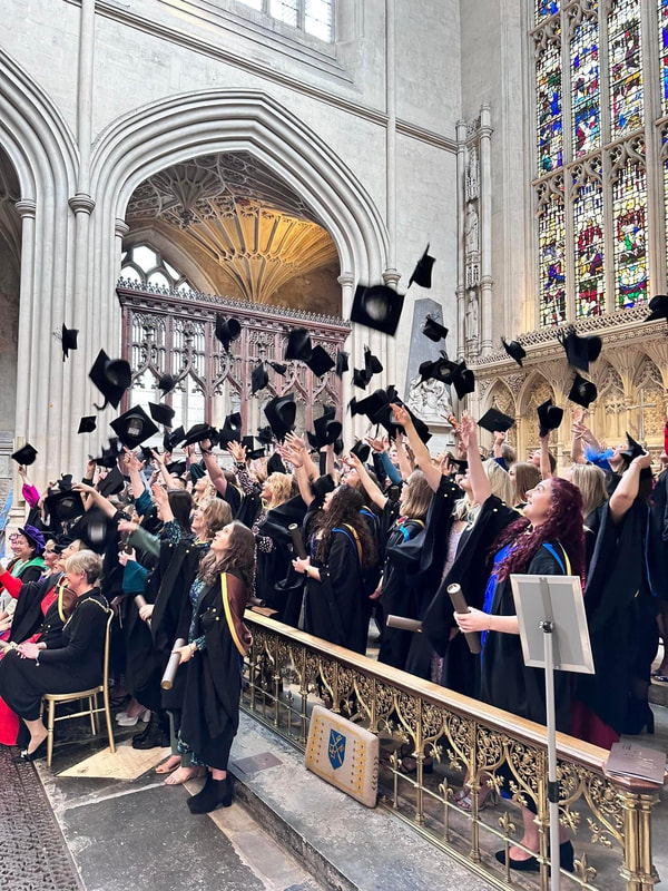 Throwing hats in the air at Bath Abbey, celebrating a Norland graduation