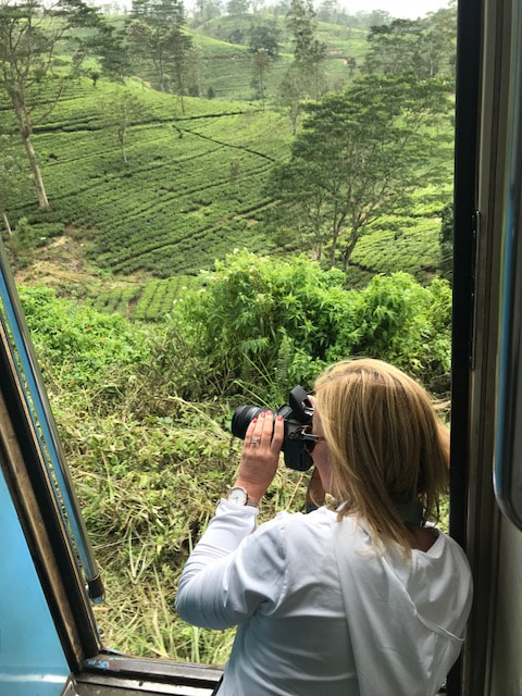 woman taking photo out of train door sri lanka