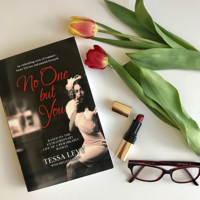 flat lay of book no one but you by tessa levy with lipstick and flower