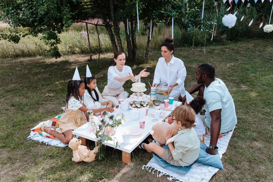 Children and moms enjoying an outdoor birthday party