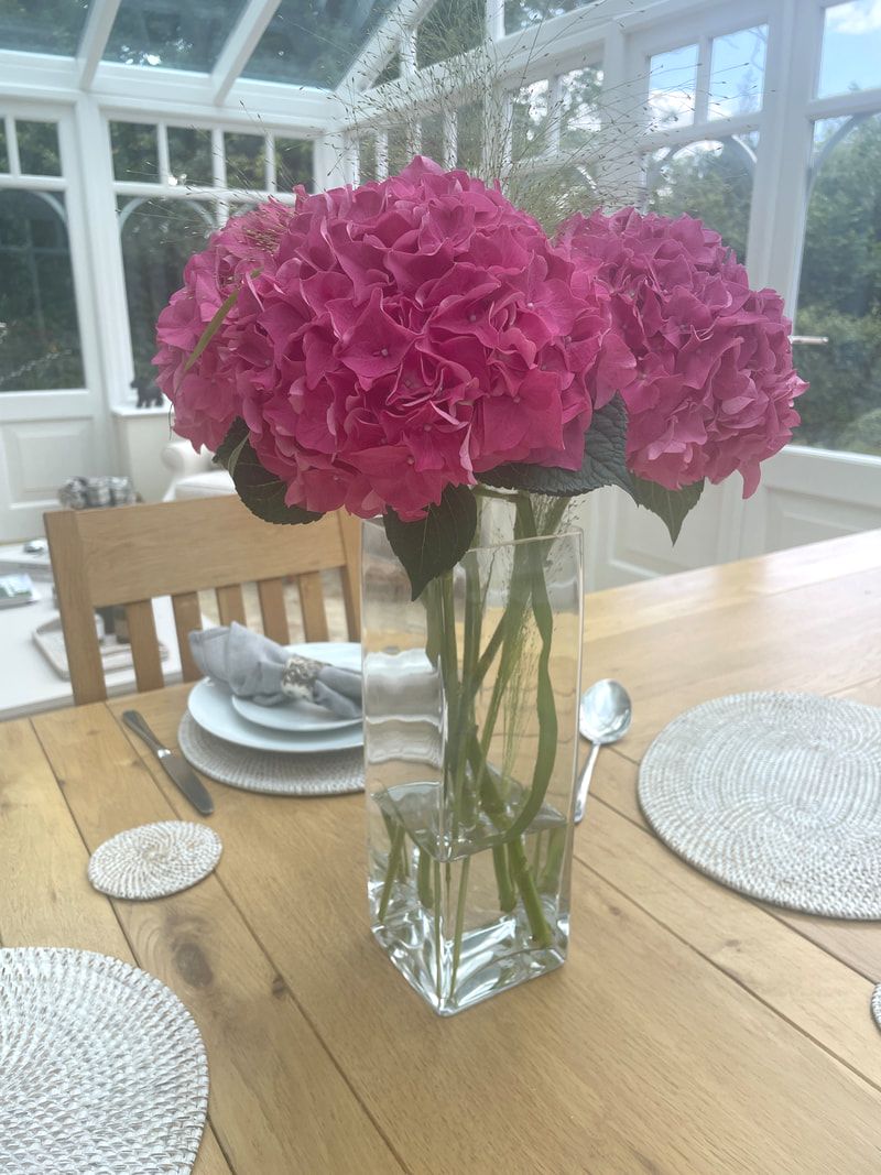 pink flowers on dining table in conservatory | review of cook my grub