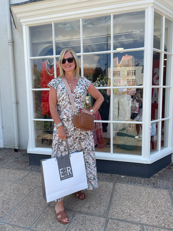 Michelle standing outside Elizabeth Rose a fashion boutique at Tenterden, Michelle is holding a shopping bag.