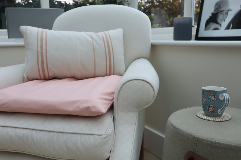 the enora air cushion in relieving peach being use on a cream laura ashley armchair