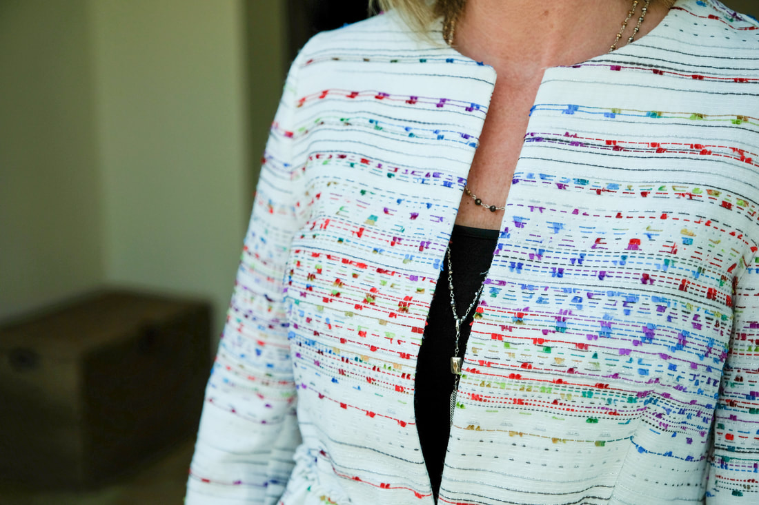 close up of embroidered jacket and necklace