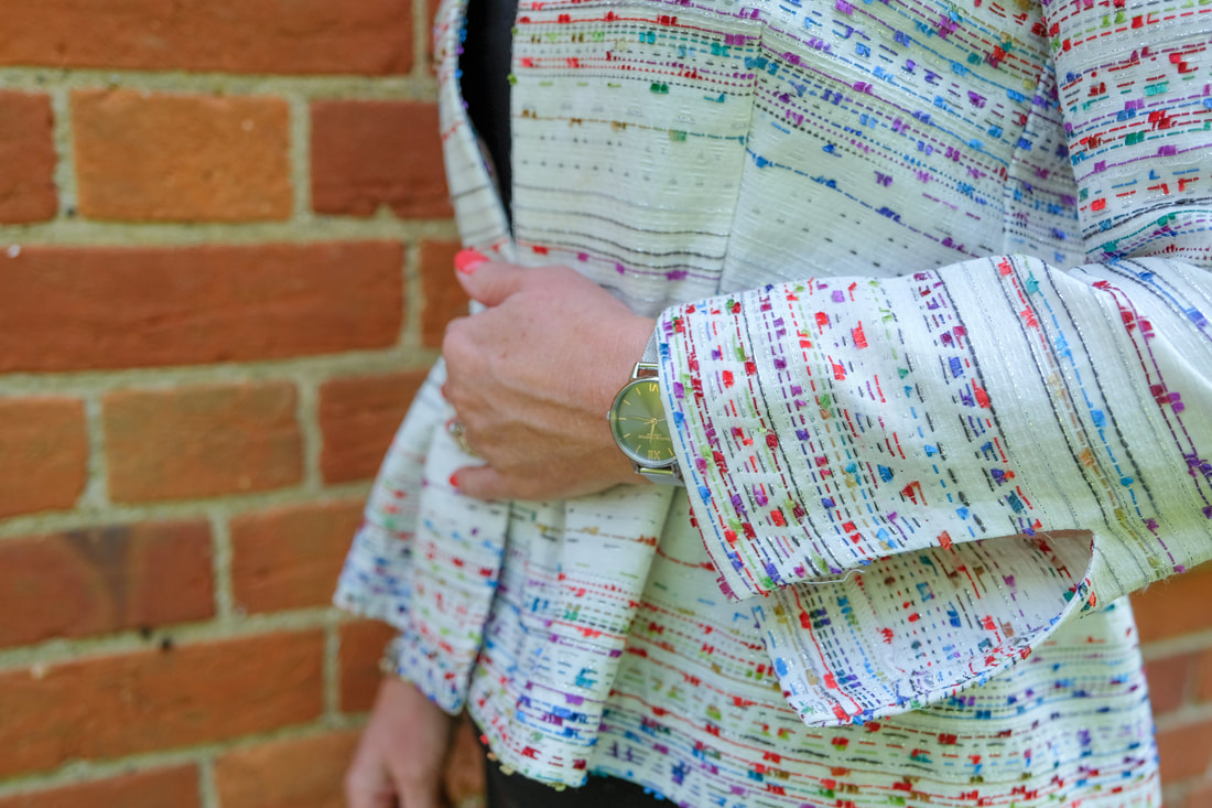 close up of peplum jacket with pretty sleeves by brick wall