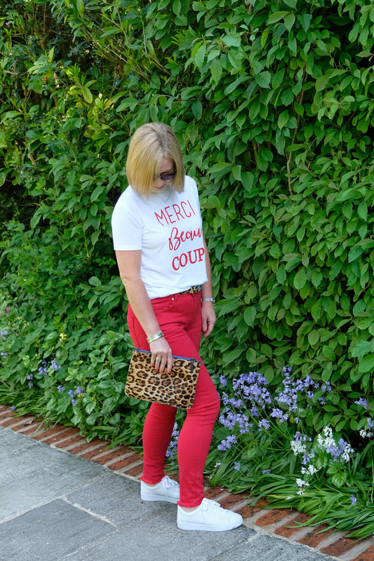 woman in red jeans and animal print bag