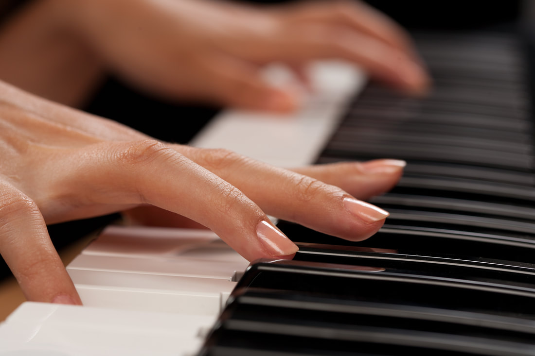 close up of woman's hands playing the piano