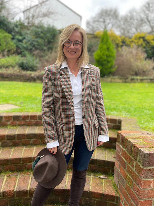 standing on the brick steps in the garden holding a wool fedora hat
