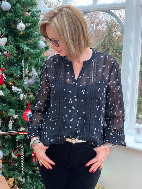 wearing black sheer blouse with white stars on