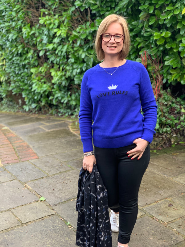 woman wearing black jeans with love rules blue jumper from hush