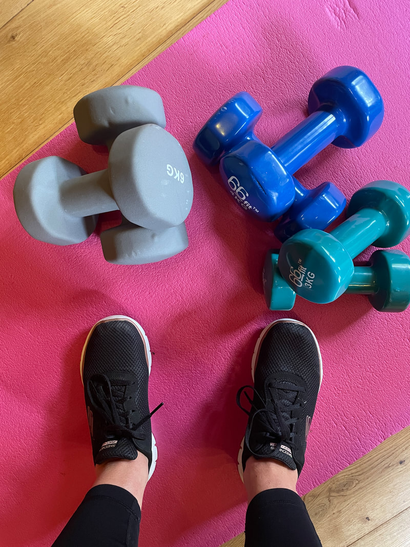 standing on a pink workout mat with dumbbells | the best exercise and diet tips for women over 50