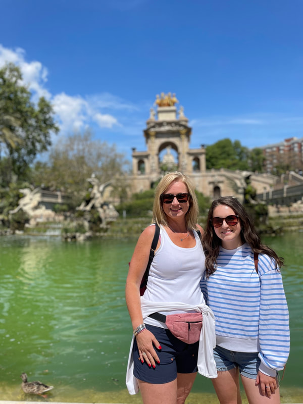 two women standing in front of the fountain at the park in Barcelona