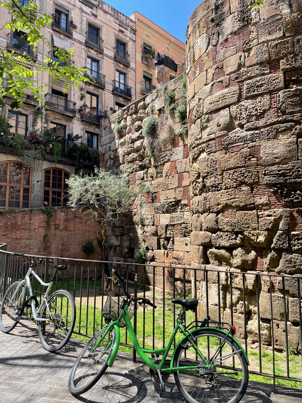 Bikes in front of railings by the old city wall in Barcelona