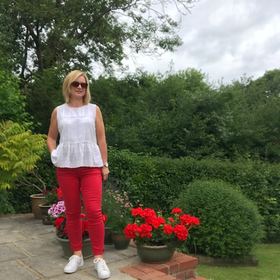 woman wearing red jeans and white top