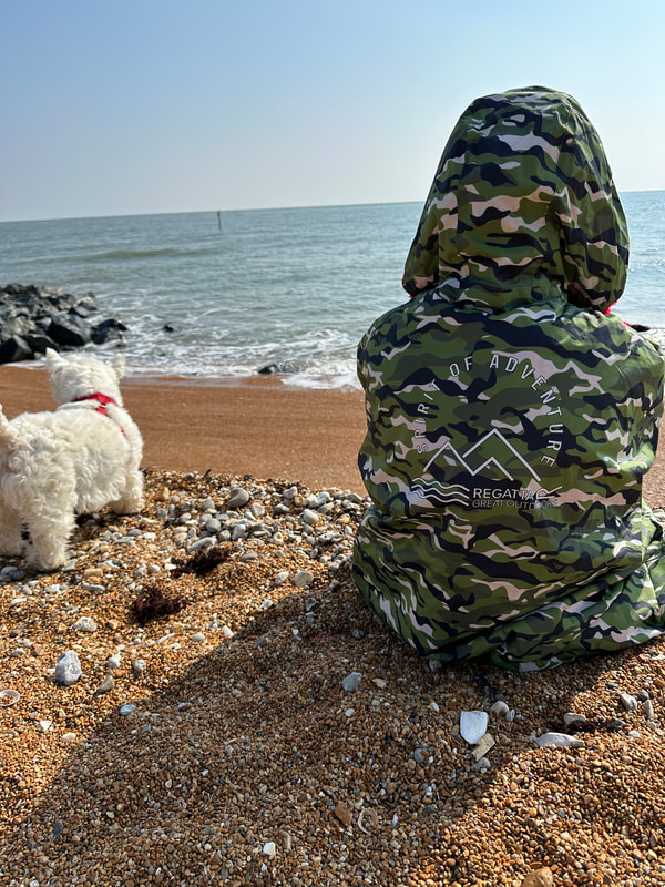 michelle sitting on the beach next to her westie dog at ventnor on the isle of wight