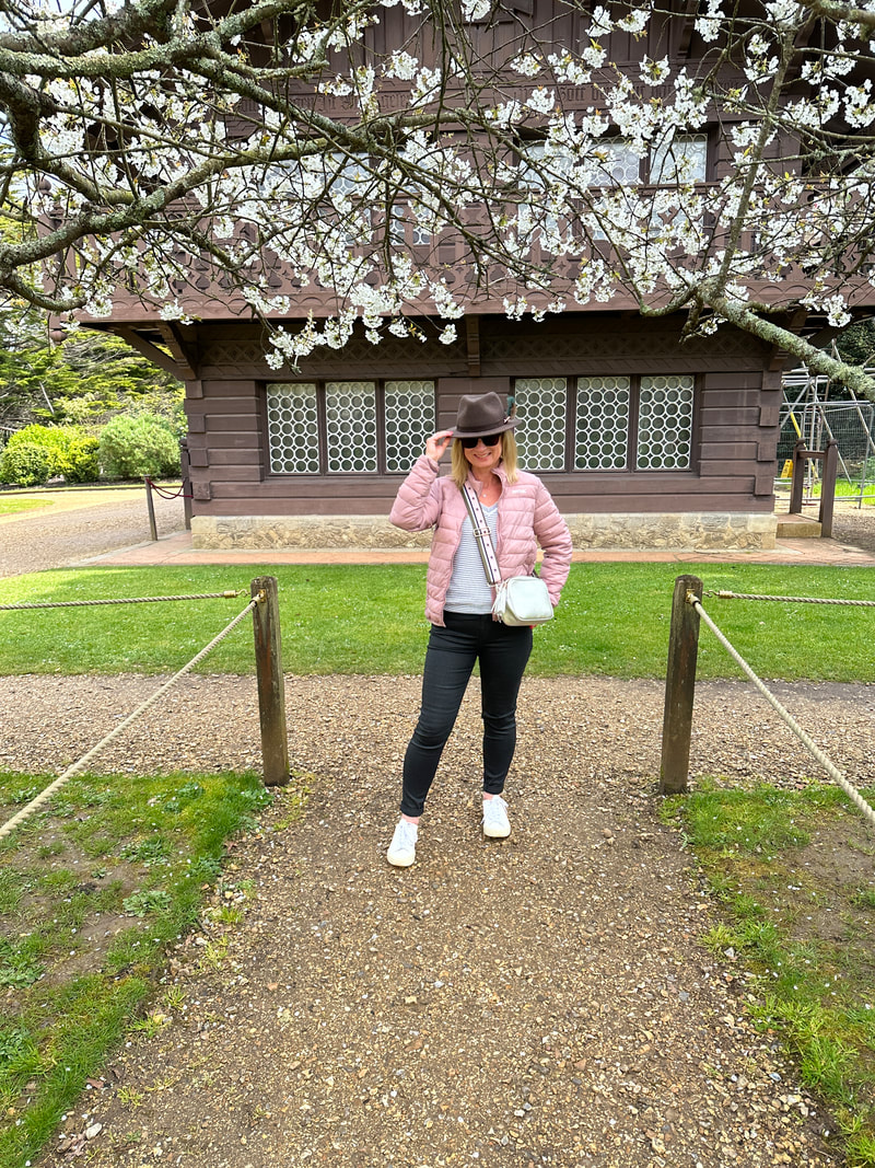 michelle is standing under the sprint blossom in front of the swiss cottage at osborne house