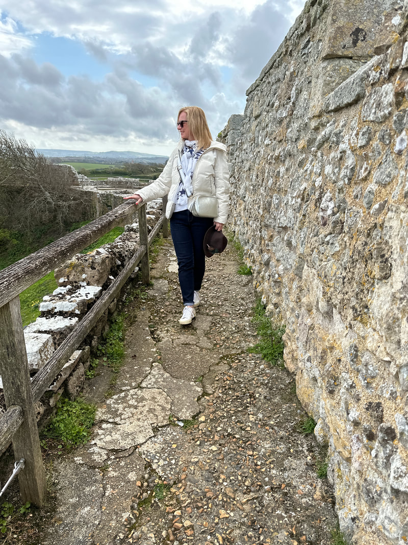 michelle is wearing a cream jacket and is walking along the wall at carisbrook castle on the isle of wight