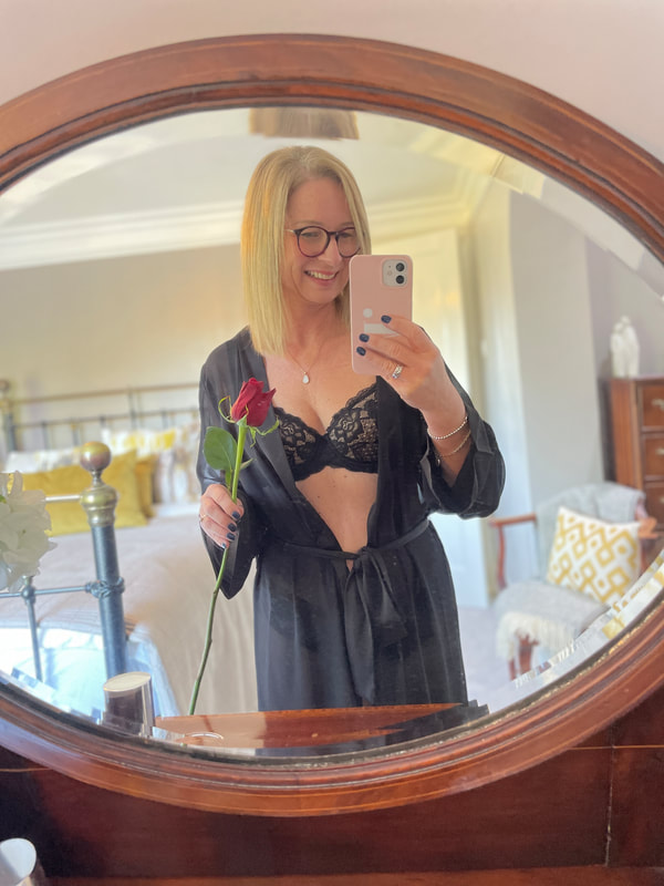 Michelle is in her bedroom wearing Juliemay lingerie with a black sheer gown and holding a single red rose