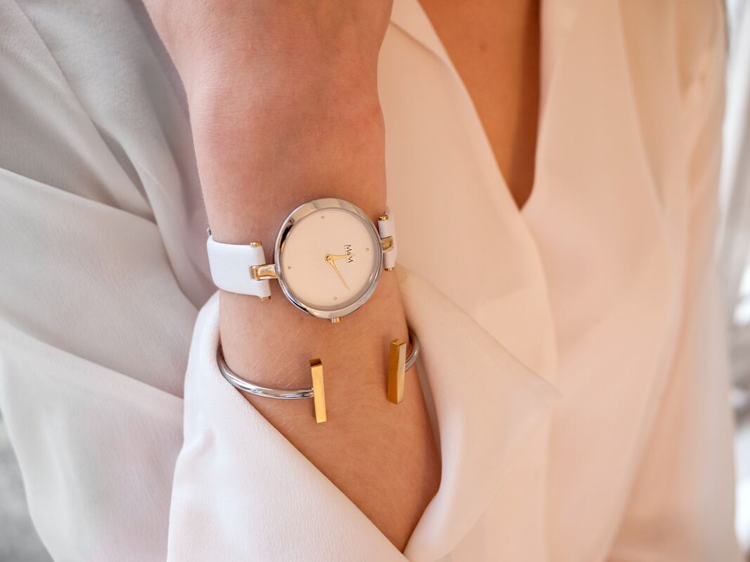 woman in a cream blouse with a white and silver watch and bracelet