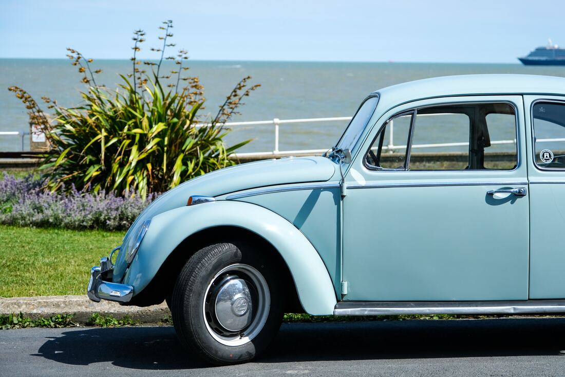 blue VW Beatle by the sea | Broadway Autocentres Bucks