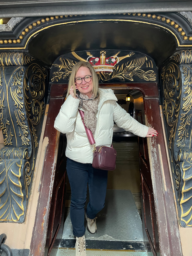 Michelle standing in the entrance to HMS Victory and listening to an audio guide