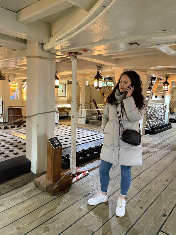 Emily is listing to the audio guide on the deck on HMS Victory at Portsmouth Historic Dockyard