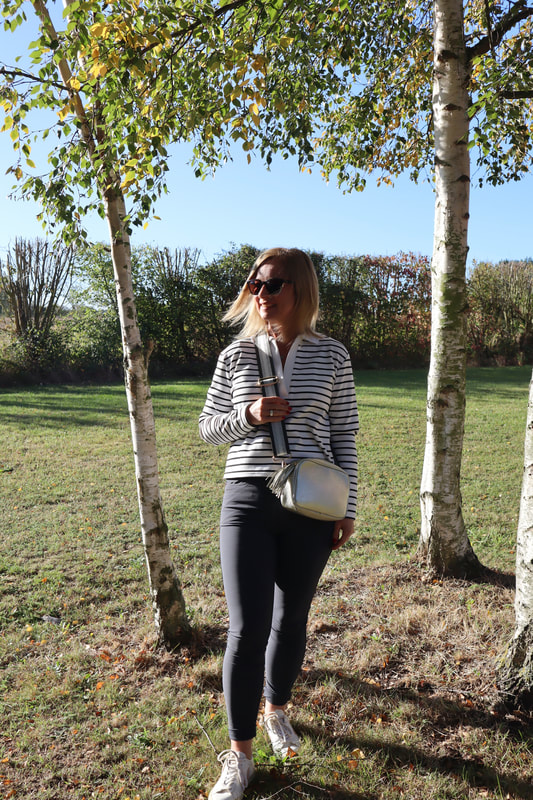 Michelle is standing in the sun between silver birch trees at potters resorts five lakes