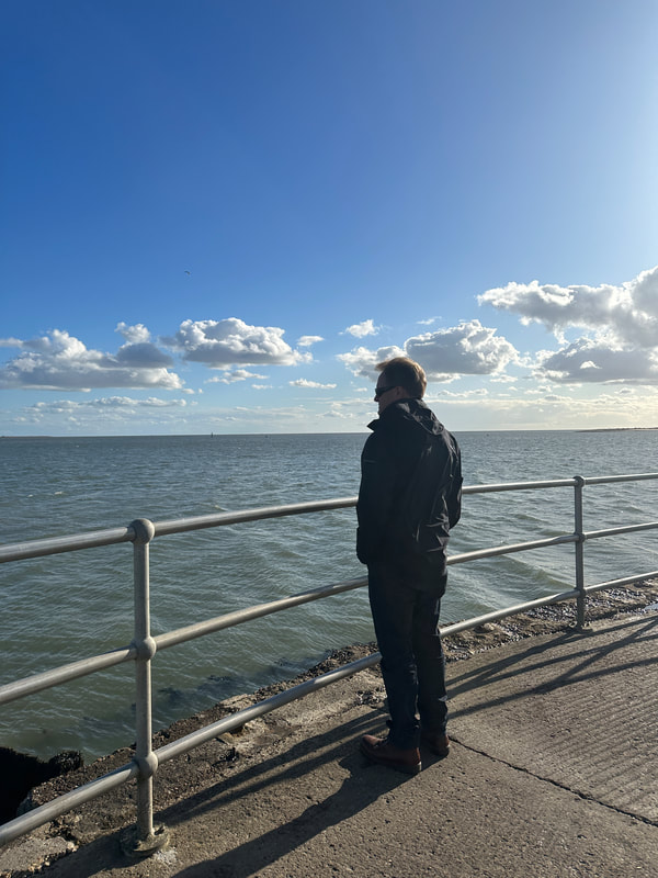 man looking out to sea at brightlingsea essex