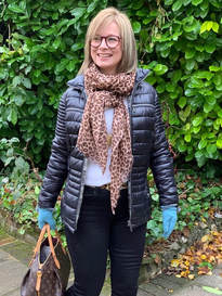 wearing animal print scarf with black and a pop of colour with teal gloves