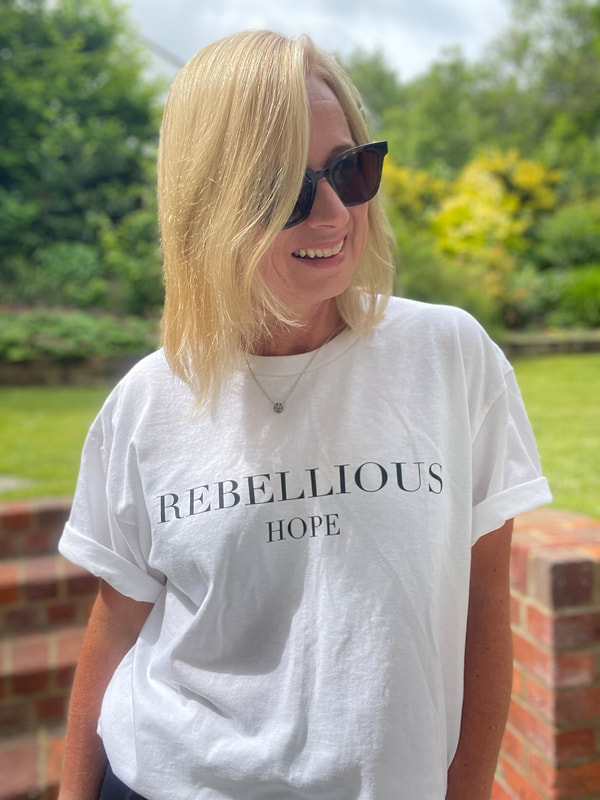 woman in garden wearing the bowelbabe rebellious hope white t-shirt