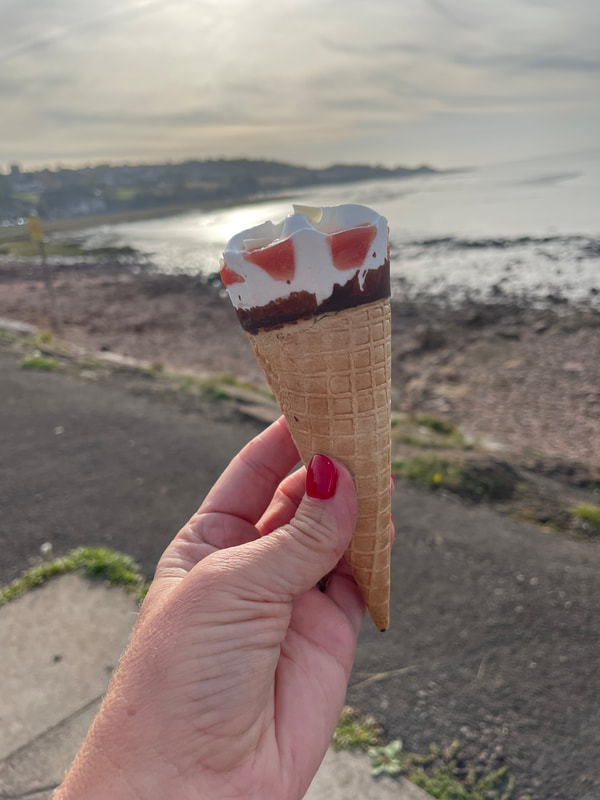 holding a cornetto strawberry ice cream at portishead beach