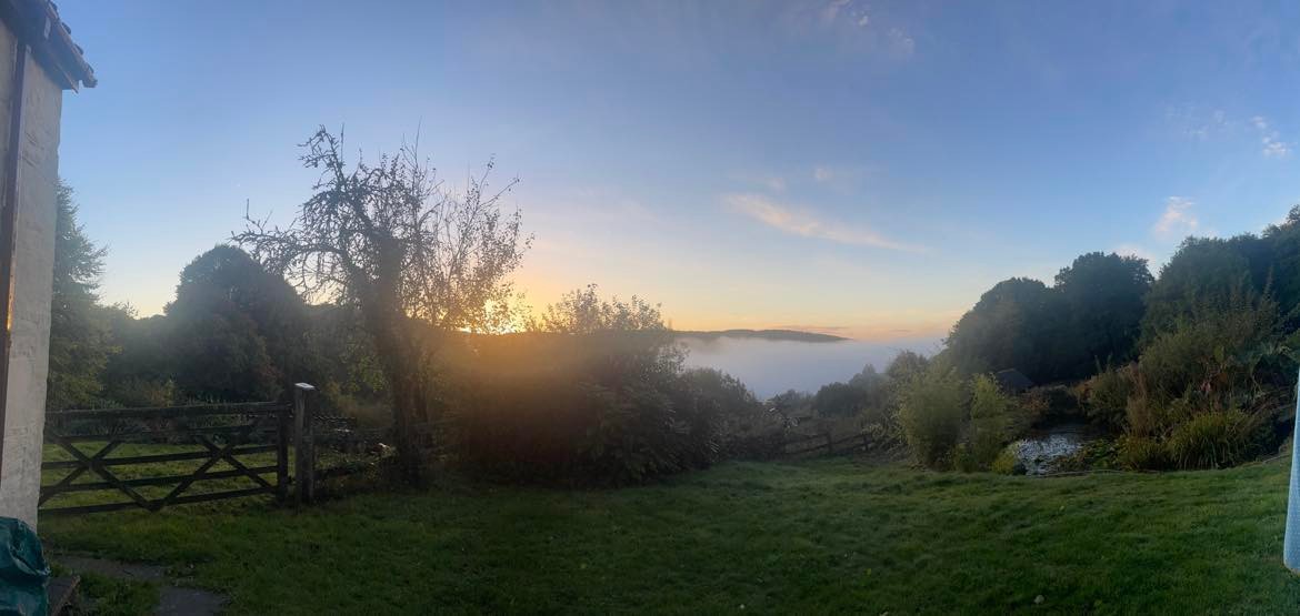 a view of the valley at hill farm - a room with a view - showing the early morning low cloud as the sun comes up