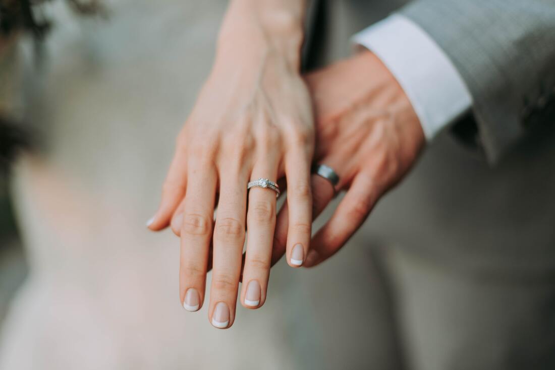 man and woman's hands with wedding rings at a wedding | 5 reasons why people put off writing a Will