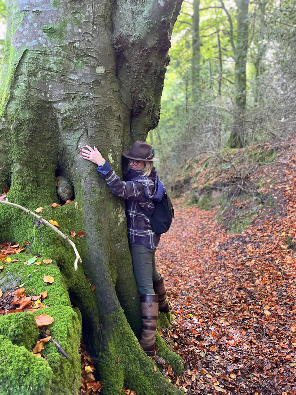 a woman hugging an ancient tree in the forest near tintern in wales