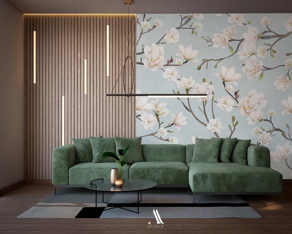 Green corner sofa in living room with blue magnolia blossom wallpaper
